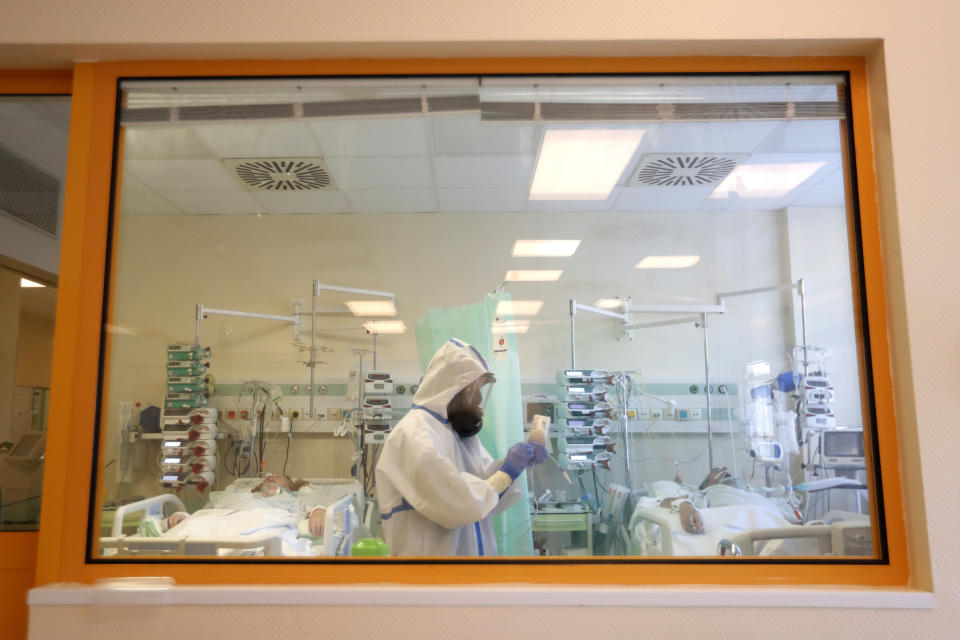 Health care worker attends to COVID-19 patients at an intensive care unit (ICU) at a hospital in Kyjov, Czech Republic, Thursday, Oct. 22, 2020. With cases surging in central Europe, some countries are calling in soldiers, firefighters, students and retired doctors to help shore up buckling health care systems. Many faced a shortage of medical personnel even before the pandemic, and now the virus has sickened many health workers, compounding the shortfall. (AP Photo/Petr David Josek)