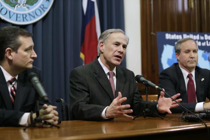 Governor Greg Abbott (C) speaks alongside Senator Ted Cruz (L) and Attorney General Ken Paxton on February 18, 2015 about the lawsuit filed by a Texas-led coalition of 26 states challenging President Obama's executive action on immigration (AFP Photo/Erich Schlegel)