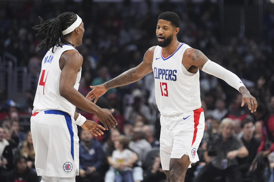 Los Angeles Clippers forward Paul George (13) celebrates after scoring with guard Terance Mann (14) during the first half of an NBA basketball game Sunday, Jan. 21, 2024, in Los Angeles. (AP Photo/Marcio Jose Sanchez)