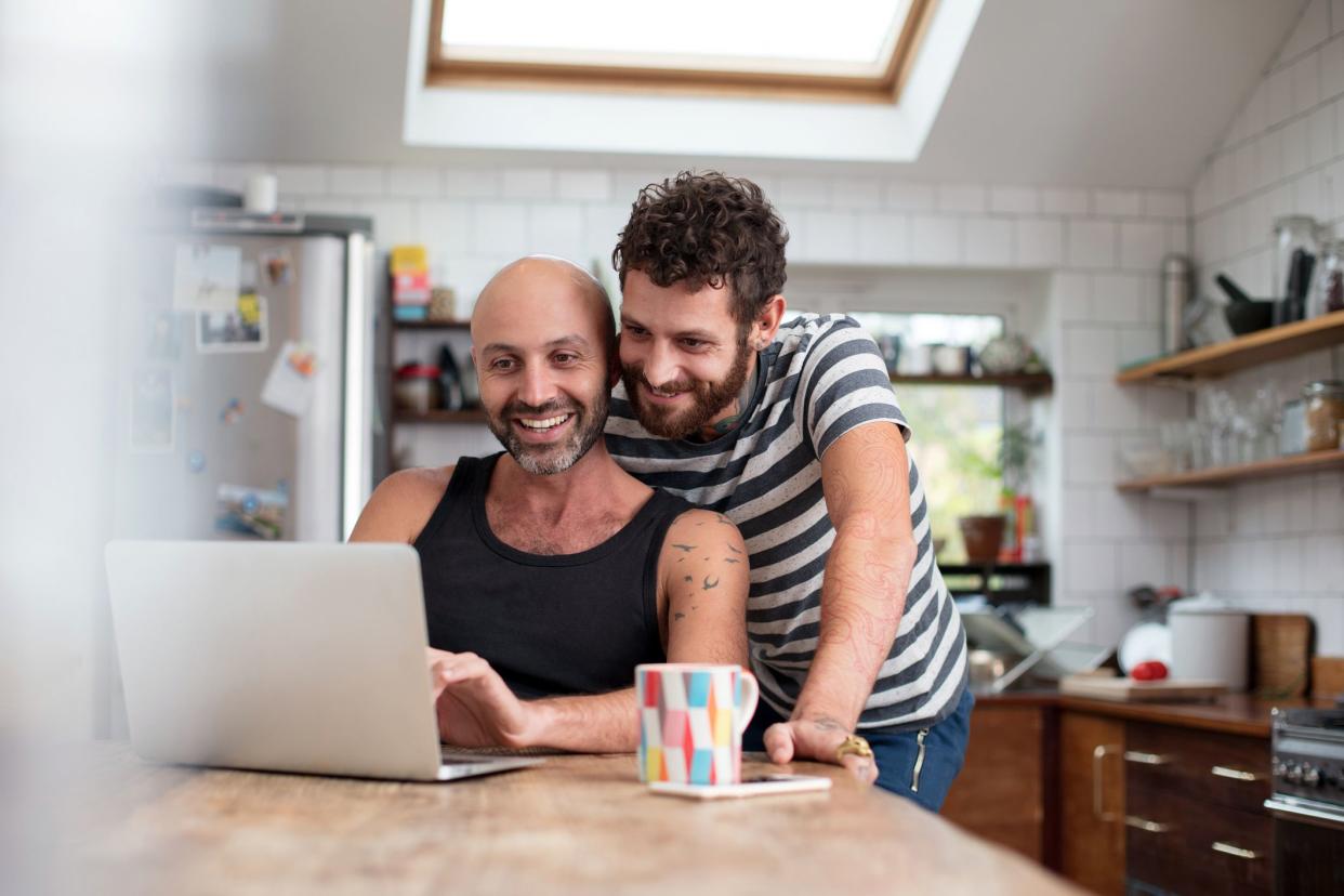 couple in kitchen looking at laptop