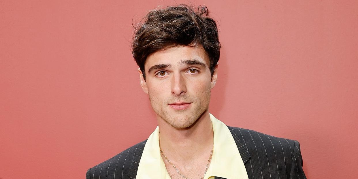 jacob elordi in a pale yellow open collar shirt and pin striped suit