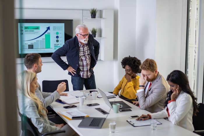 senior manager clearly displeased with his younger workers accomplishments