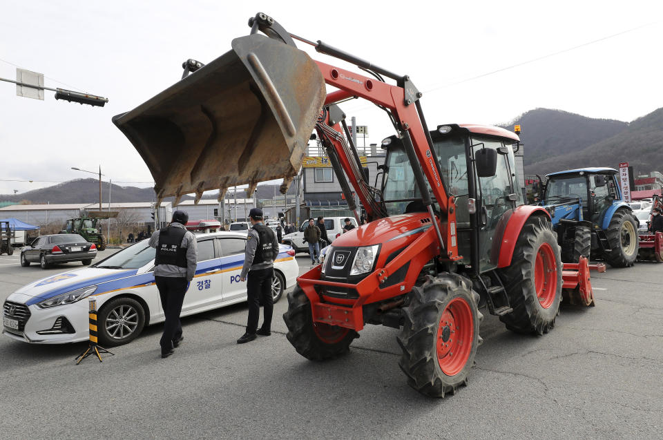 In this Wednesday, Jan. 29, 2020, photo, residents block a road with their tractors to protest the government's decision to quarantine South Koreans returning from Wuhan in their home town in Asan, South Korea. The death toll rose to 170 in the new virus outbreak in China on Thursday as foreign evacuees from the worst-hit region begin returning home under close observation and world health officials expressed "great concern" that the disease is starting to spread between people outside of China.(Kim Jun-beom/Yonhap via AP)