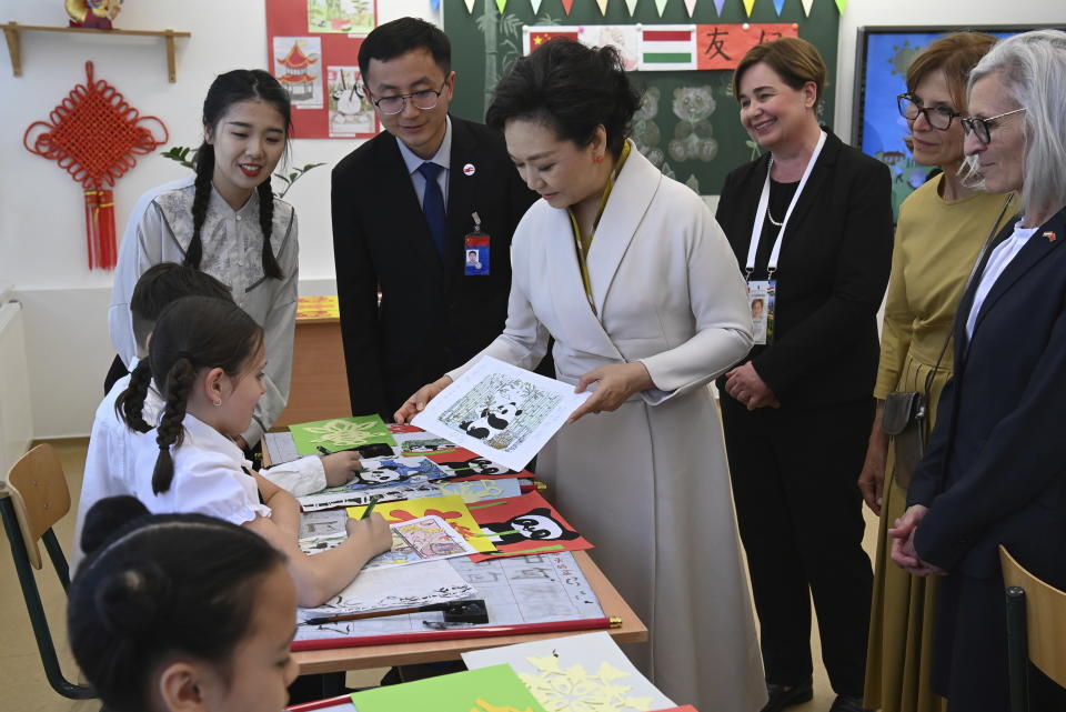 Peng Liyuan, center, wife of Chinese President Xi Jinping speaks with third graders as she, and Aniko Levai, second right, wife of Hungarian Prime Minister Viktor Orban visit a classroom with headmaster Zsuzsanna Erdelyi, right, at the Chinese-Hungarian bilingual school of Budapest, Hungary, Thursday May 9, 2024 during the state visit of President Xi to Hungary. (Zoltan Mathe/MTI via AP)