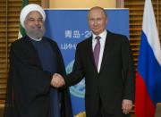 Rencontre entre les présidents russe Vladimir Poutine et iranien Hassan Rohani en marge du sommet à Qingdao le 9 juin 2018