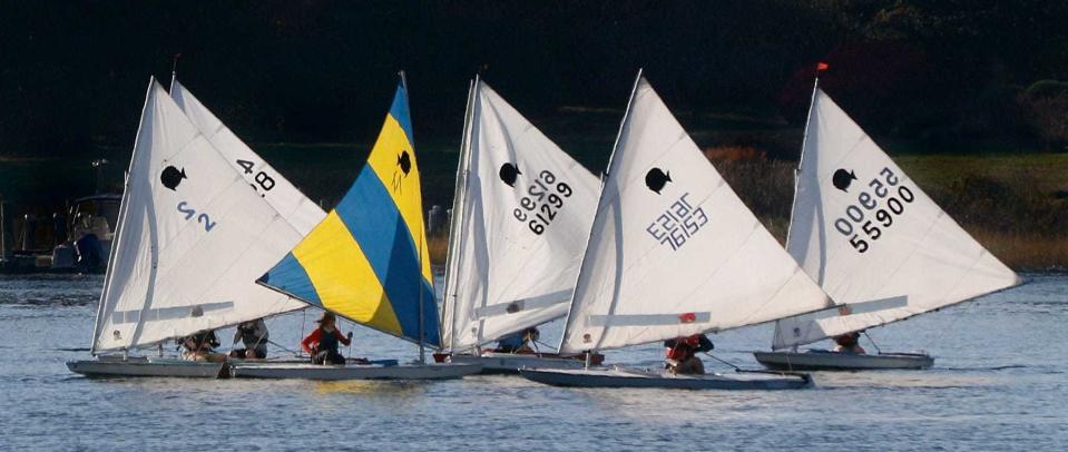 A small sunfish regatta under sail in the waters off Warren Town Beach on a Sunday afternoon.
afternoon.