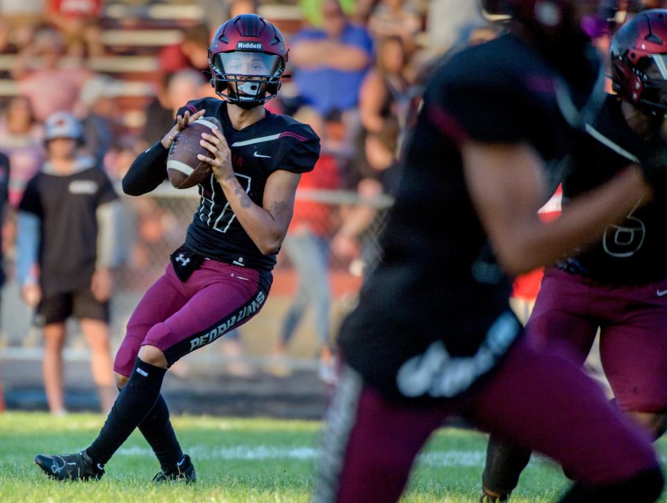 Peoria High quarterback Tino Gist looks for a receiver as the Lions battle Metamora on Friday, Aug. 26, 2022 at Peoria Stadium.