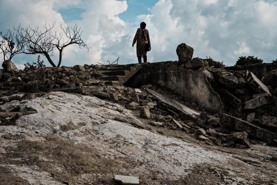 A person walks up a flight of steps near rubble