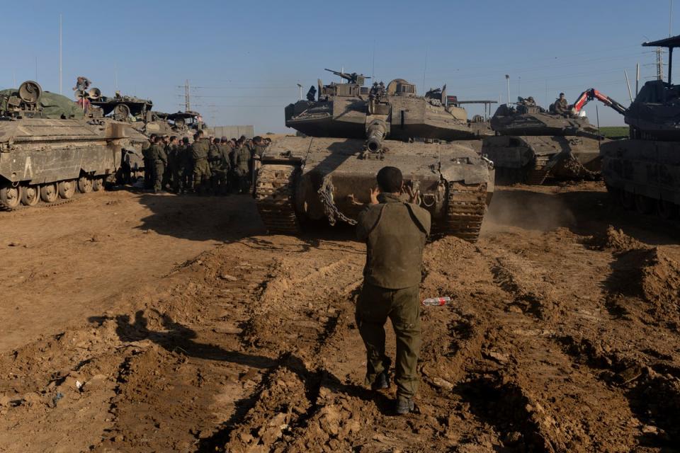 An Israeli soldier directs a tank near the border with the Gaza Strip (Getty)