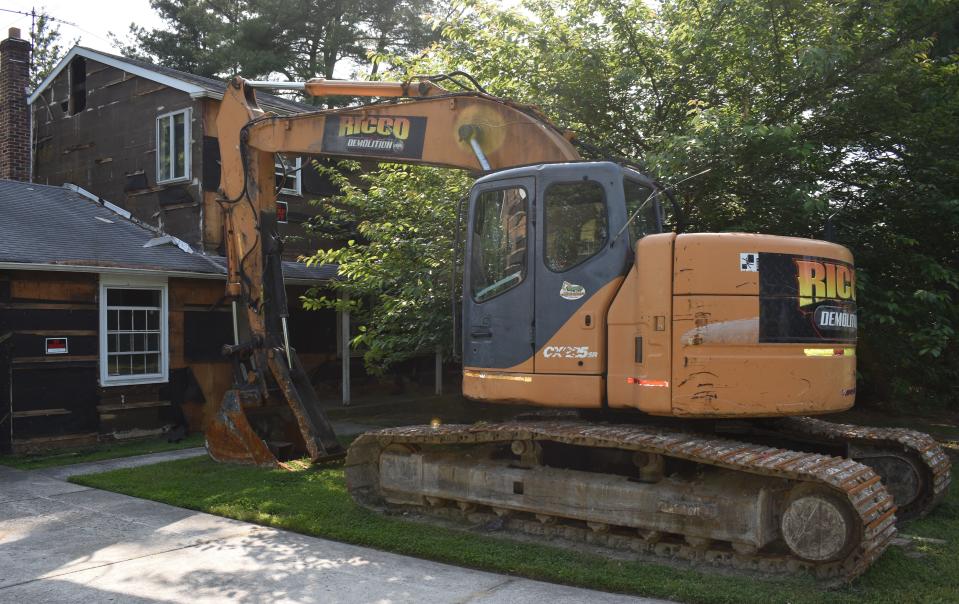 An excavator sits idle outside a Wynwood Avenue home that's been prepared for demolition.