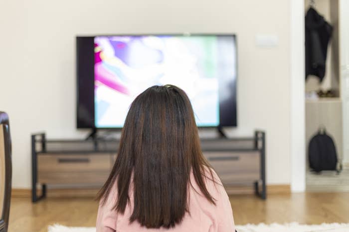 A little girl in front of the television set