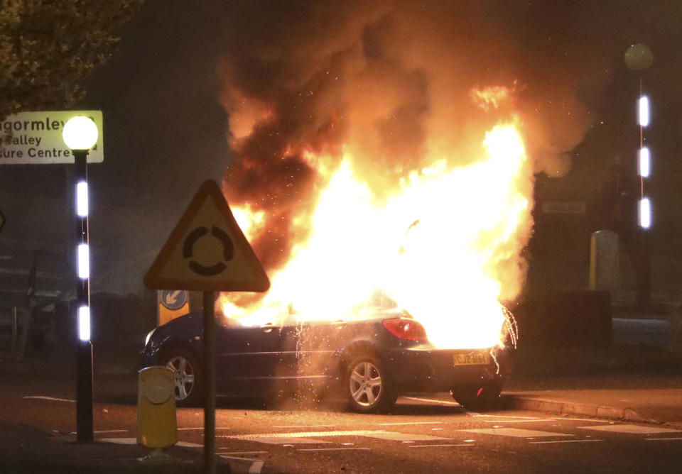 A car burns after it was hijacked by Loyalists at the Cloughfern roundabout in Newtownabbey, Belfast, Northern Ireland, Saturday, April 3, 2021. Masked men threw petrol bombs and hijacked cars in the Loyalist area North of Belfast. Loyalists and unionists are angry about post-Brexit trading arrangements which they claim have created barriers between Northern Ireland and the rest of the UK. (Peter Morrison/PA via AP)