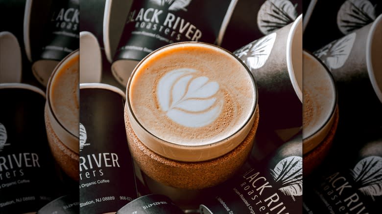 Cup of coffee in the center of cups with Black River logo