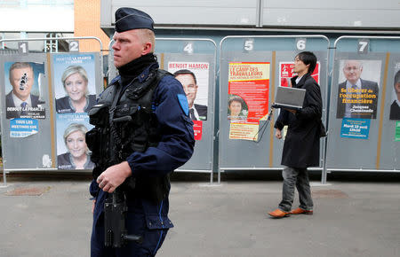 A policeman stands near a polling station during the first round of 2017 French presidential election in Henin-Beaumont, France, April 23, 2017. REUTERS/Pascal Rossignol