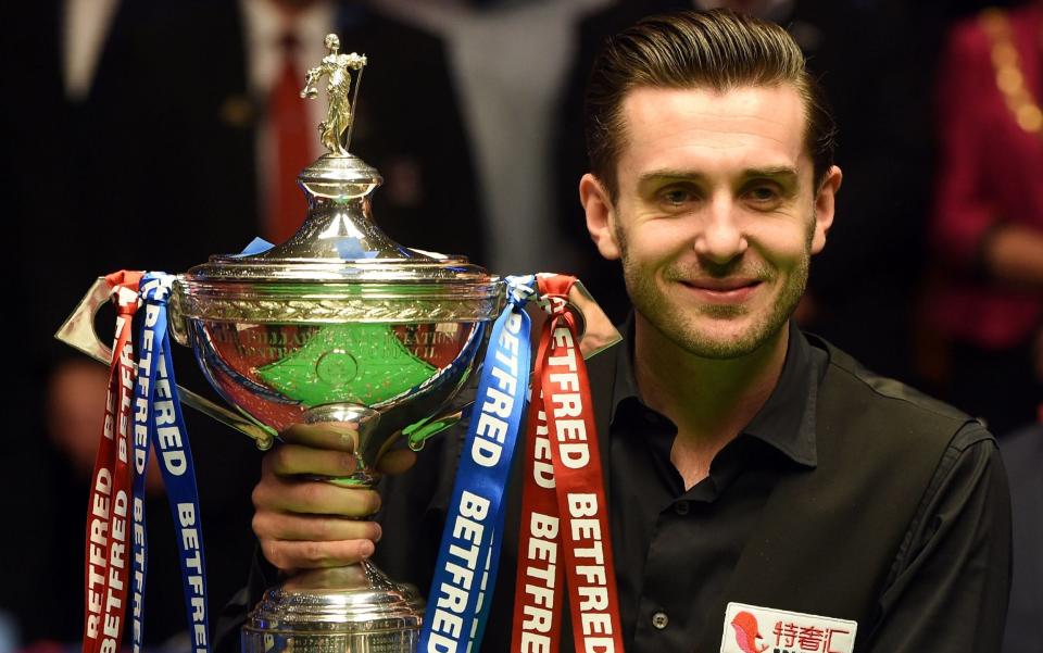 Mark Selby lifts the trophy after winning back-to-back world snooker championships at the Crucible - AFP