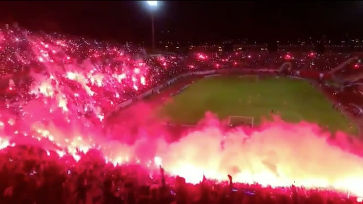 Algerian soccer fans filled a stadium in fire and red smoke. (Twitter)