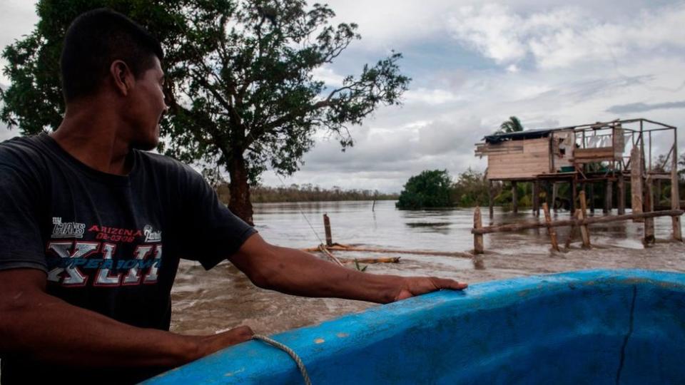 persona navega sobre una calle inundada