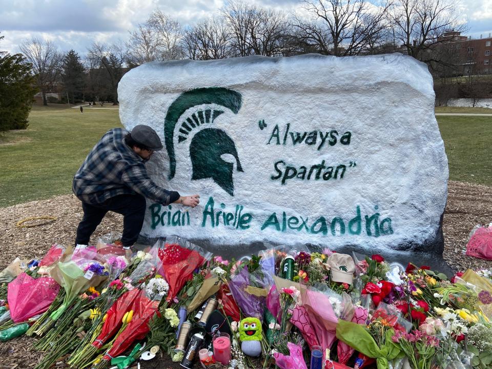 The Rock is repainted on Wednesday, Feb. 15, 2023, for at least the fourth time since a Feb. 13 mass shooting on campus by Madison Heights muralist Anthony Lee. It includes the names of the three Michigan State students killed.