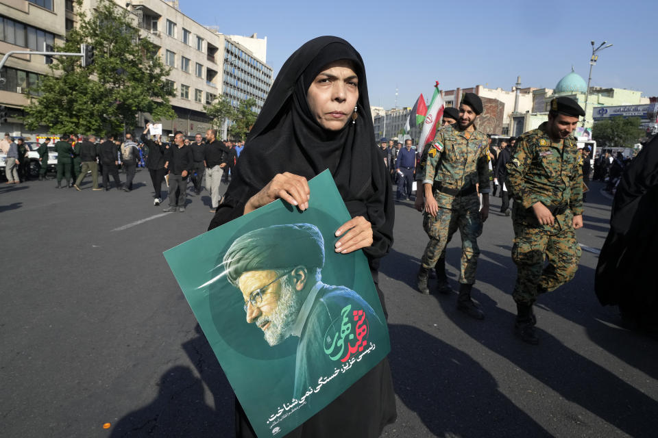 A woman holds a poster of the late Iranian President Ebrahim Raisi during a funeral ceremony for him and his companions who were killed in a helicopter crash on Sunday in a mountainous region of the country's northwest, in Tehran, Iran, Wednesday, May 22, 2024. Iran's supreme leader presided over the funeral Wednesday for the country's late president, foreign minister and others killed in the helicopter crash, as tens of thousands later followed a procession of their caskets through the capital, Tehran. (AP Photo/Vahid Salemi)