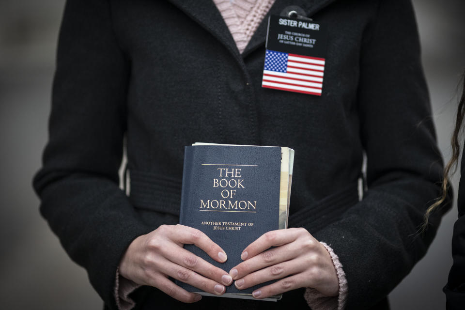 Sister Palmer, 19, holds The Book of Mormon while walking around Temple Square in Salt Lake City, on Nov. 15, 2020. Palmer, a member of The Church of Jesus Christ of Latter-day Saints, is serving an 18-month mission in Salt Lake City while waiting for her visa to continue the mission in Spain. Salt Lake City's hosting of this weekend's NBA All-Star game for the first time in three decades gives Utah another opportunity to reshape a long-held belief that the state is odd or peculiar — a years-long push that Utah Jazz owner Ryan Smith and many other influential state leaders have prioritized. (AP Photo/Wong Maye-E, File)