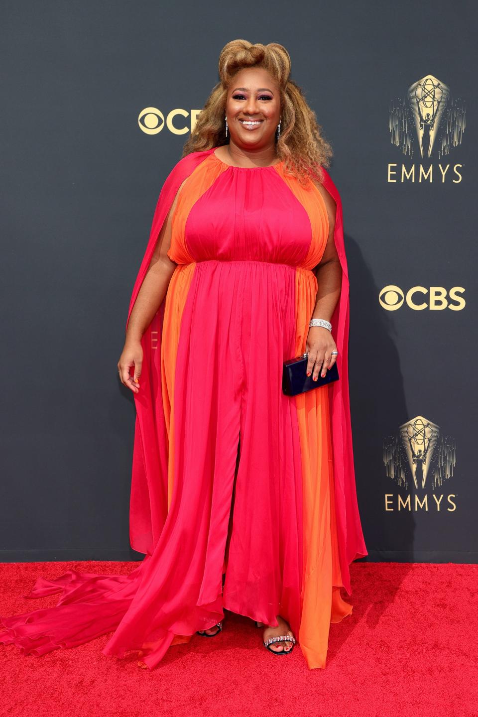 Ashley Nicole Black wears a pink and orange dress on the Emmys red carpet.