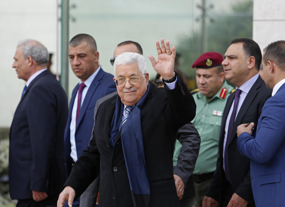 Palestinian President Mahmoud Abbas, center, waves as he arrives to lay a wreath at the tomb of late Palestinian leader Yasser Arafat, inside the Mukataa government compound, in the the West Bank city of Ramallah as Palestinians commemorate the 14th anniversary of his death, Sunday, Nov. 11, 2018. (AP Photo/Nasser Shiyoukhi)