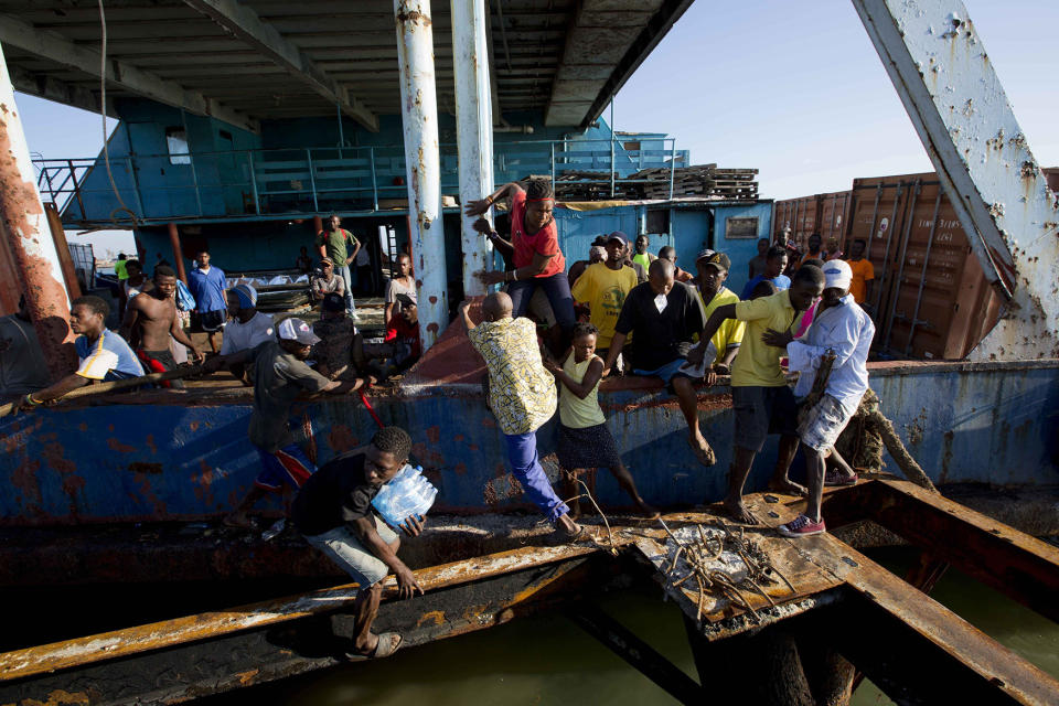 People try to get off a boat carrying aid as national police arrive to secure the vessel carrying supplies