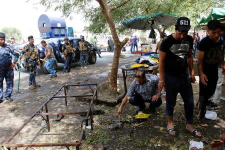 Residents and Iraqi security forces inspect the site where a suicide bomber detonated his explosive vest at the entrance to Kadhimiya, a mostly Shi'ite Muslim district in northwest Baghdad, Iraq July 24, 2016. REUTERS/Khalid al Mousily