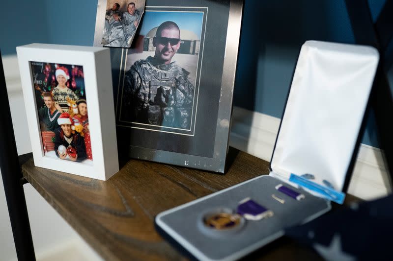 A picture of Retired Army Captain Dan Berschinski while he was serving is seen next to his Purple Heart on a shelf at his home in Atlanta