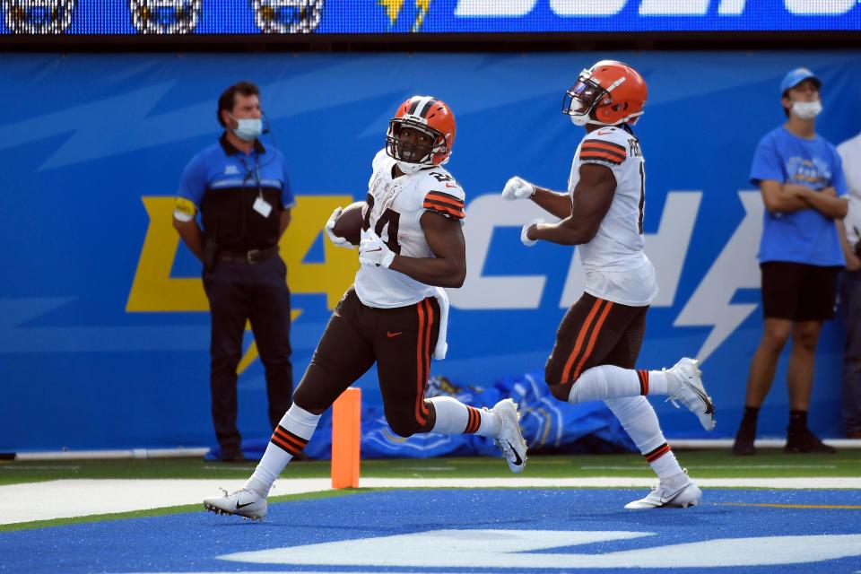 Cleveland Browns running back Nick Chubb, left, scores a touchdown against the Los Angeles Chargers during the second half of an NFL football game Sunday, Oct. 10, 2021, in Inglewood, Calif. (AP Photo/Kevork Djansezian)