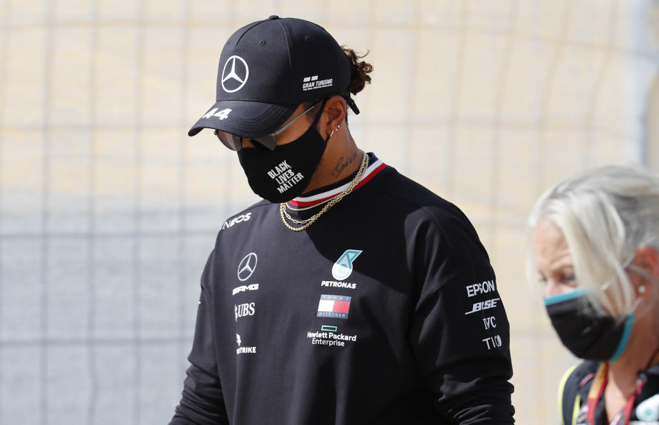 El piloto Lewis Hamilton (izquierda) camina en la pista del circuito de Algarve, sede del Gran Premio de Portugal de la Fórmula Uno, el jueves 22 de octubre de 2020. (AP Photo/Armando Franca)