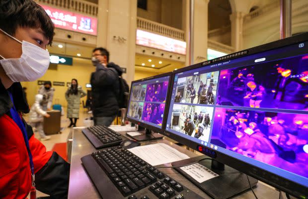 A staff member wearing a mask monitors thermal scanners that detect temperatures of passengers at the security check inside the Hankou Railway Station in Wuhan, Hubei province, China January 21, 2020.