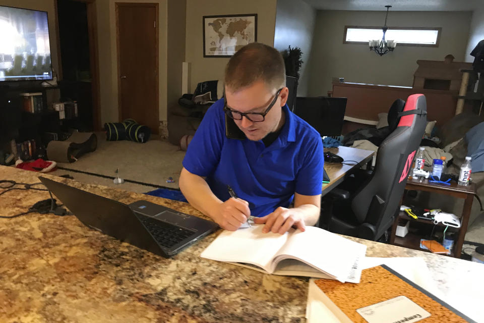 Brenton Nesemeier, who manages COVID-19 case managers and field managers at the North Dakota Department of Health, works at his home in Fargo, N.D., on Dec. 11, 2020. He said the state curtailed much of its contact tracing among the general public as the virus surged, and relying on people who test positive to tell anyone they were in close contact with. (Zachery Noble via AP)