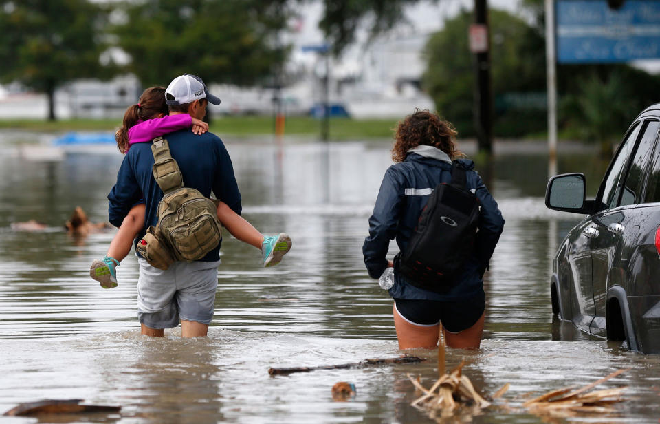 <p>Don Noel carries his daughter Alexis, 8, with his wife Lauren, right as they walk through a flooded roadway to check on their boat in the West End section of New Orleans, Wednesday, June 21, 2017. Tropical Storm Cindy formed Tuesday in the Gulf of Mexico, hovering south of Louisiana as it churned tides and spun bands of heavy, potentially flooding rain onto the central and eastern Gulf Coast. (Photo: Gerald Herbert/AP) </p>