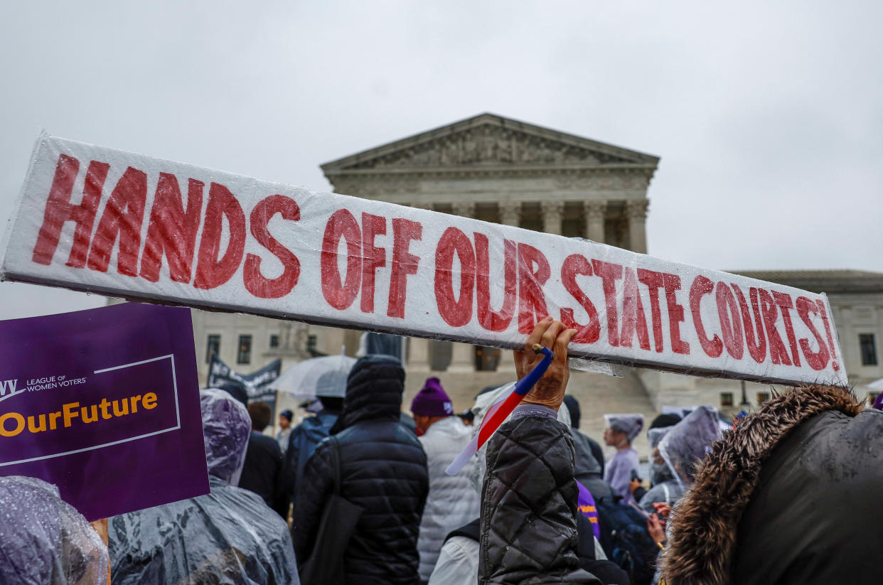 Demonstrators gather outside the U.S. Supreme Court as the justices hear oral arguments in Moore v. Harper, a Republican-backed appeal to curb judicial oversight of elections, on Wednesday. 