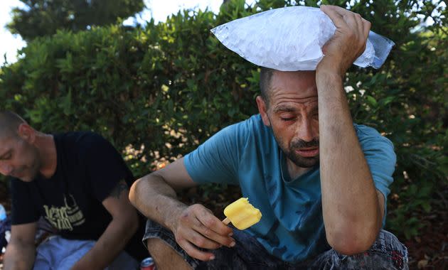 Michael Williams, right, cools off with a frozen pop and a bag of ice as temperatures in Santa Rosa pushed 112 degrees Monday. (Photo: via Associated Press)