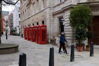 FILE PHOTO: People walk along a deserted street in London