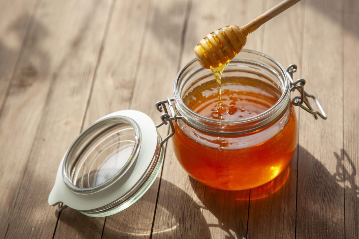 jar of honey and wood stick