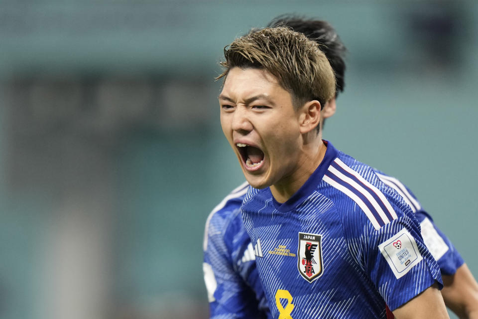 Japan's Ritsu Doan, right, celebrates after scoring his side's opening goal during the World Cup group E soccer match between Germany and Japan, at the Khalifa International Stadium in Doha, Qatar, Wednesday, Nov. 23, 2022. (AP Photo/Luca Bruno)