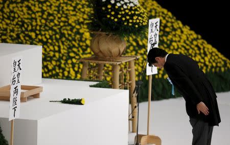 Japan's Prime Minister Shinzo Abe bows after offering a chrysanthemum flower to the war dead during a memorial service ceremony marking the the 69th anniversary of Japan's surrender in World War Two, at Budokan Hall in Tokyo in this August 15, 2014 file photo. REUTERS/Toru Hanai/Files