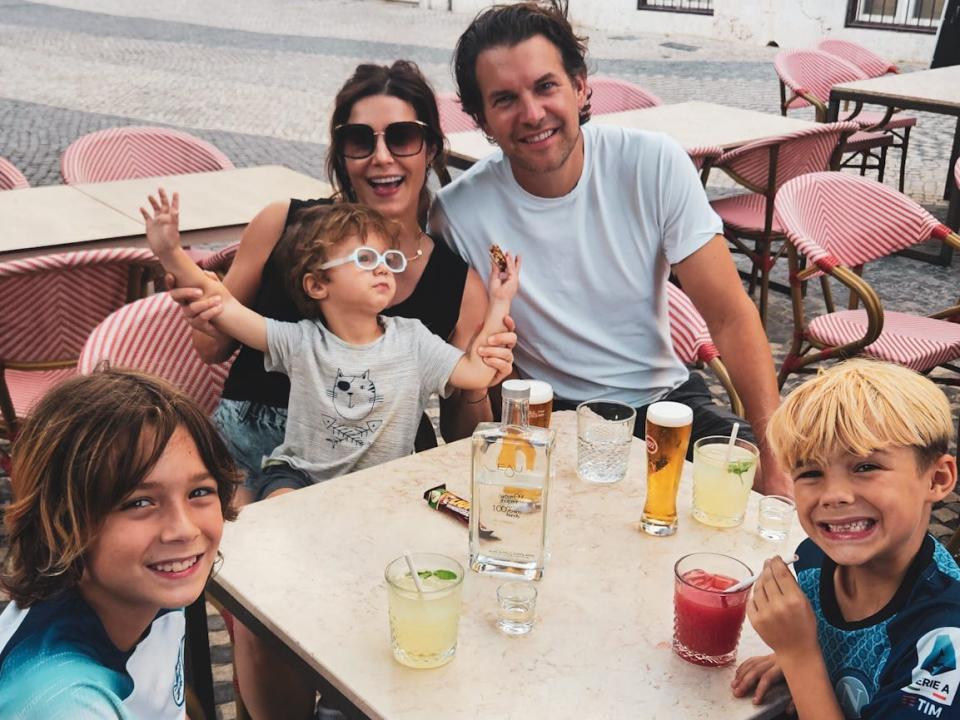 A family of five sitting in an outdoor cafe