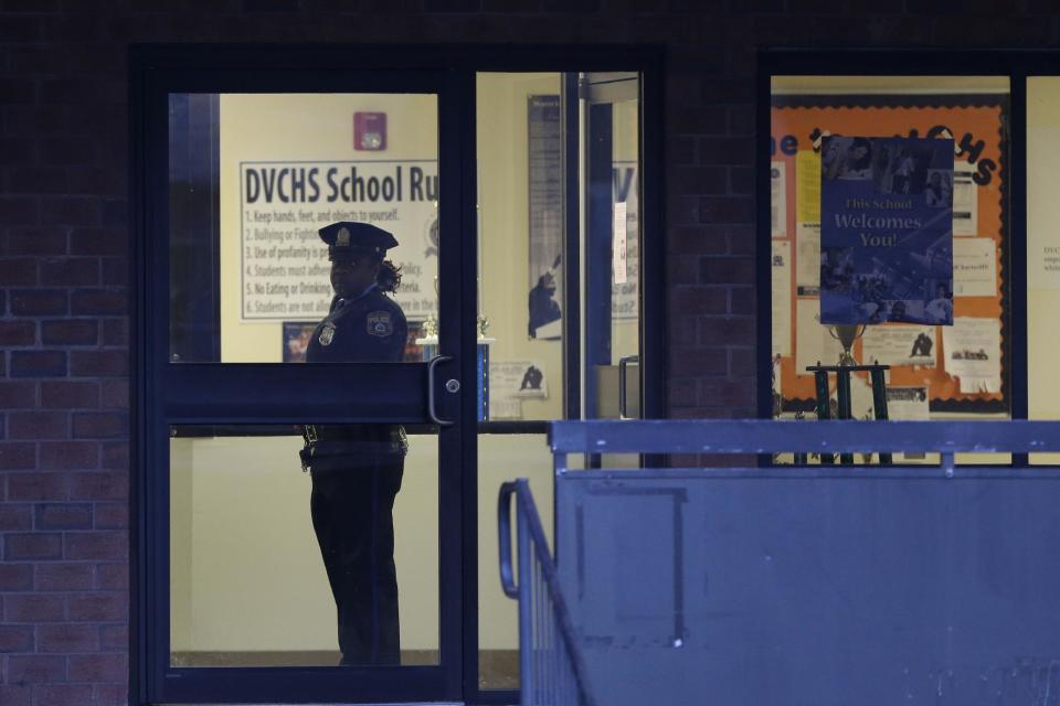 Police stands guard the Delaware Valley Charter School Friday, Jan. 17, 2014, in Philadelphia, after two students were shot by another student. A boy hanging out in the high school gym with fellow students on Friday afternoon shot and wounded two of them before fleeing and being captured near his home, police said. A male student and a female student were shot, each in an arm. The wounded students were taken to a hospital near the school, where they were listed in stable condition, police said. (AP Photo/Matt Rourke)