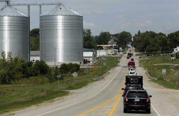 The bus carrying President Barack Obama (black in front) travels through the countryside in a secure motorcade in Poweshiek County, Iowa, while the president campaigns across the state, August 14, 2012.