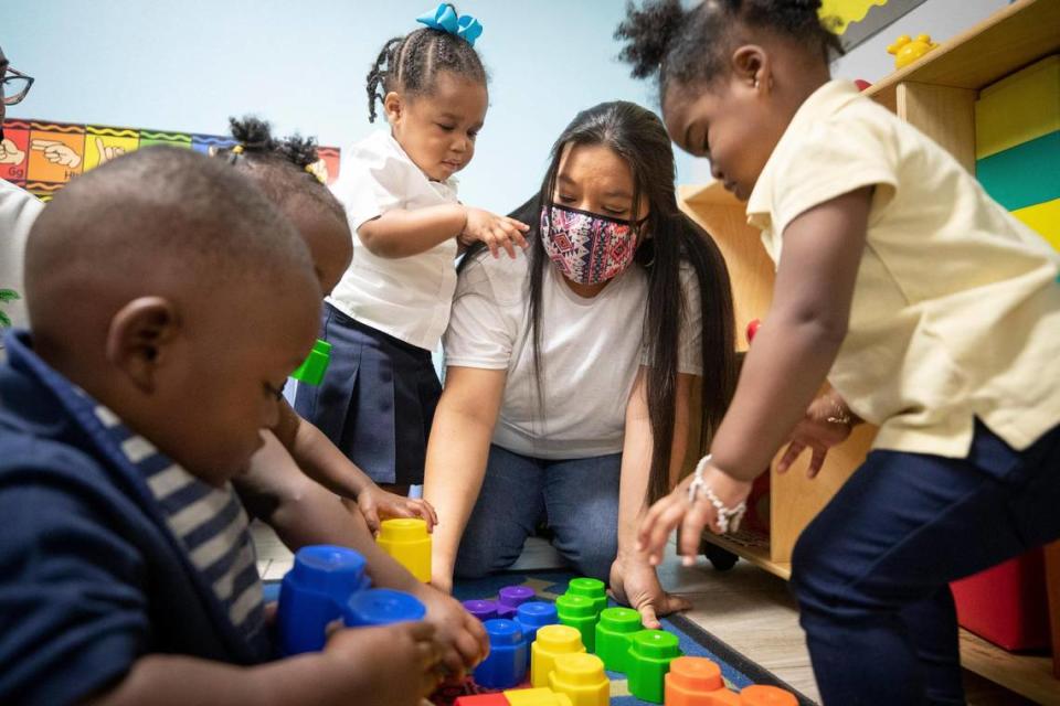 June Robles with the ECE Apprentice program helps the children build a tower during class on Oct. 5, 2021, at Good Shepherd Christian Academy in Fort Worth.