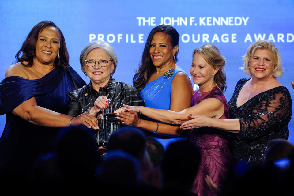 From left, Margie Bright Matthews, Katrina Shealy, Mia McLeod, Sandy Senn and Penry Gustafson all stand next to each other and place their hands on an award trophy (Brian Snyder / Reuters)