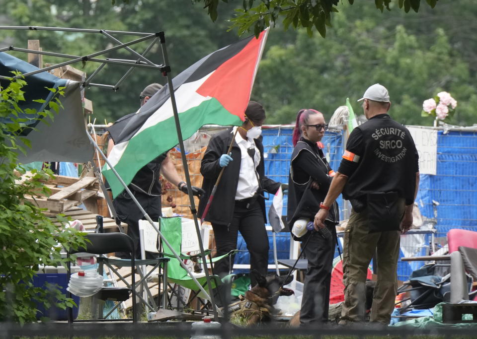 Security removes a flag as they clear the pro-Palestinian encampment at McGill University in Montreal, Wednesday, July 10, 2024. (Ryan Remiorz/The Canadian Press via AP)