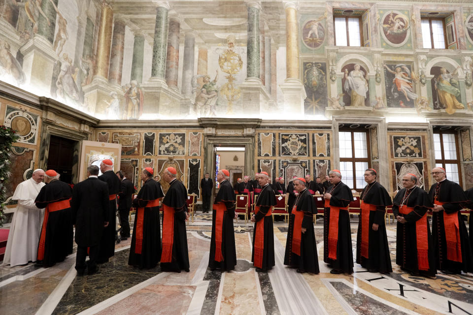 FILE - In this file photo taken on Dec. 21, 2019, Cardinals queue to greet Pope Francis on the occasion of the pontiff's Christmas greetings to the Roman Curia, in the Clementine Hall at the Vatican. Pope Francis issued tough new anti-corruption regulations Thursday to keep Vatican cardinals and managers honest, requiring them to periodically declare they aren't under criminal investigation or stashing money in tax havens, and are investing only in funds consistent with Catholic doctrine. (AP Photo/Andrew Medichini, Pool)