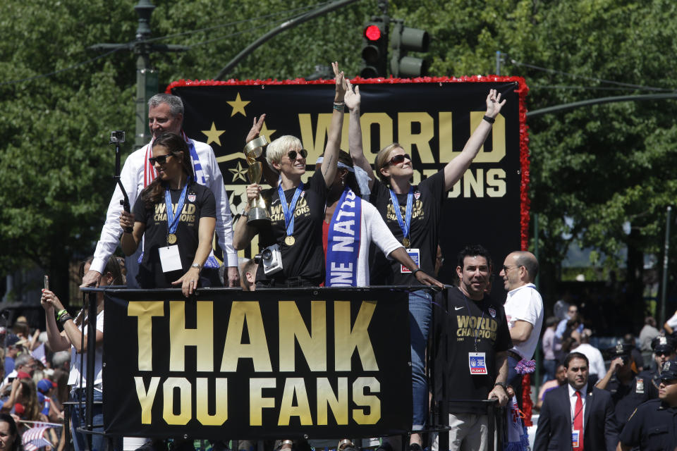 FILE - U.S. women's soccer team midfielder Megan Rapinoe, center, holds up the World Cup trophy as she wayves, while midfielder Carli Lloyd, left, New York City Mayor Bill de Blasio, left background, and head coach Jill Ellis, right, wave to the crowd as their float makes it way up Broadway's Canyon of Heroes during the ticker tape parade to celebrate the U.S. women's soccer team World Cup victory, Friday, July 10, 2015, in New York. On Sunday, Sept. 24, 2023, Rapinoe will play her final game in a U.S. jersey when the United States faces South Africa at Chicago's Soldier Field. (AP Photo/Mary Altaffer, File)