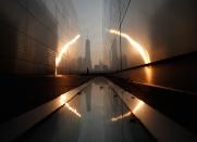 A man runs past the 9/11 Empty Sky memorial at sunrise across from New York's Lower Manhattan and One World Trade Center in Liberty State Park in Jersey City, New Jersey, September 11, 2013. (REUTERS/Gary Hershorn)