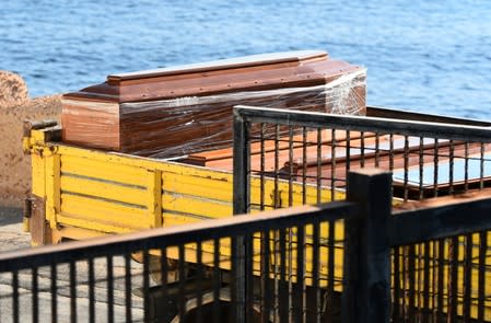 Coffins are seen as emergency services carry bodies from a migrant shipwreck that took place on October 7 back to the island of Lampedusa